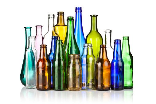 multi colored glass bottles standing together with a white background 